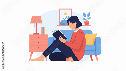 Person sitting on floor reading a book next to couch