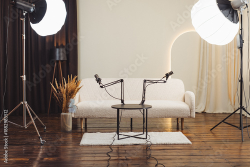 Podcast studio setup with microphones, lighting, and a couch ready for recording session