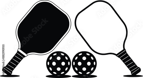 A pair of pickleball paddles positioned with two textured balls in a striking black and white design