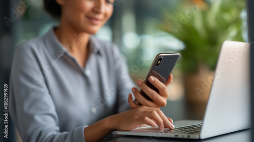 Faceless woman entering password laptop holding smartphone secure login concept two factor authentication cybersecurity online access protection digital identity verification