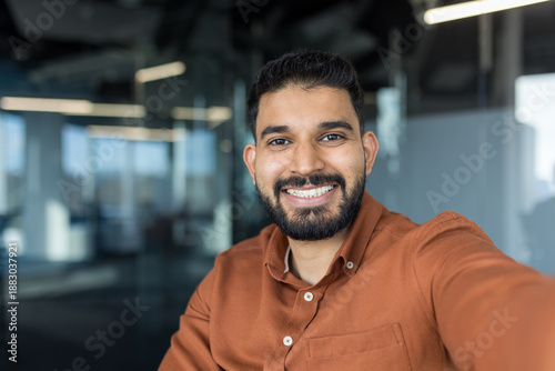 Canvastavla Indian businessman with a beard smiling confidently, taking a selfie in a modern