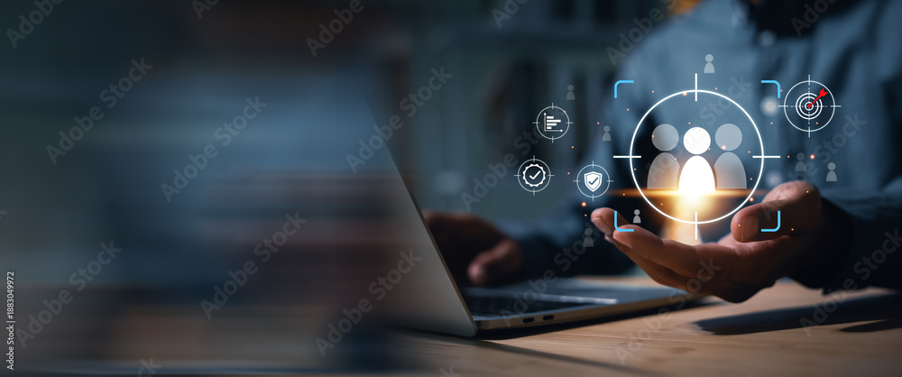 Naklejka premium Businessman uses a laptop to target and select key personnel using digital technology. The image conveys an HR strategy focused on finding the right employees to drive the organization towards future 