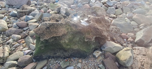 Eroding rock formation on a pebble and stone beach