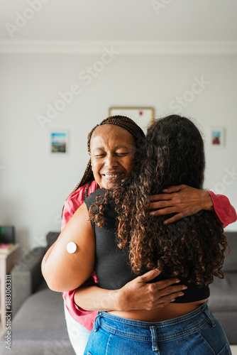 Photography African mother hugging her daughter with diabetes patch - Family lifestyle and p