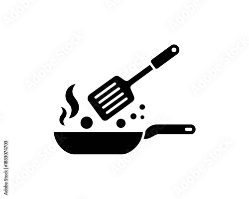 Cooking spatula in frying pan with steam and bubbles