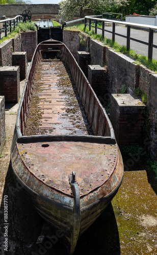 Fotografija Hull of old canal narrowboat in drydock beside canal