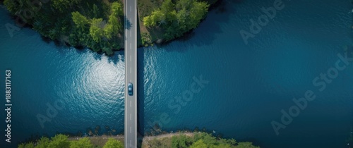Aerial shot of bridge asphalt road with vehicles driving across a blue water lake in Finland