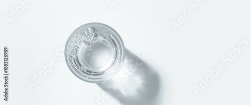 Flat lay of a glass of water on a white background, top view