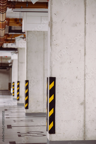 Concrete parking pillars with black and yellow safety stripes in underground garage