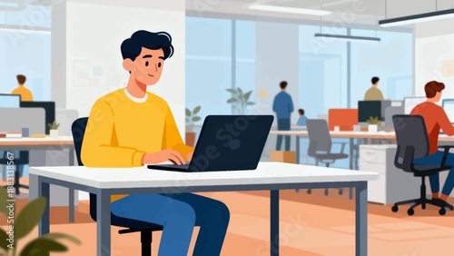 A man is sitting at a desk with a laptop in front of him. He is wearing a yellow shirt. There are several other people in the background, some of whom are sitting in chairs