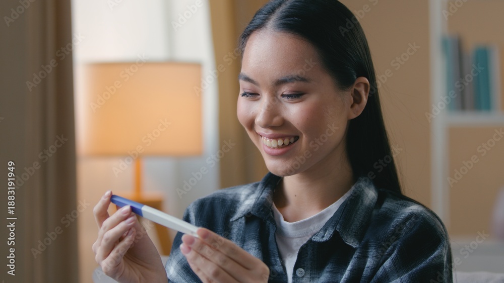 Φωτογραφία Happy pregnant Asian Korean woman surprised holding positive pregnancy test at h