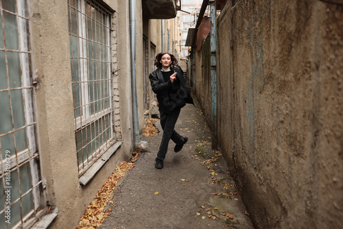 Canvastavla A youth strides happily down a narrow alley, flanked by aged buildings with peeling paint