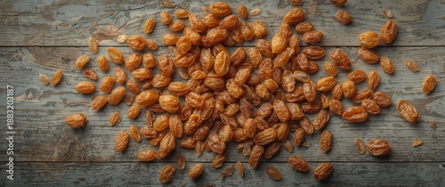 Arrangement of numerous whole dry golden sultana raisins on grey wooden background