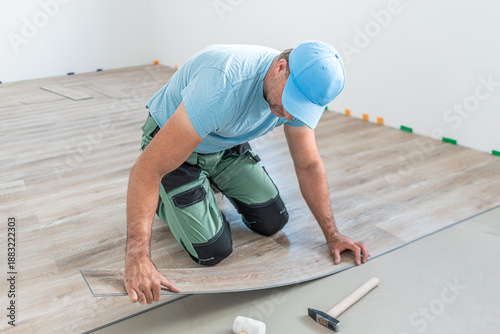 Floating floor work. The worker inserts the board of vinyl plank to the click system of Floating floor.