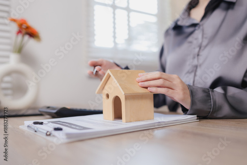 Hispanic real estate agent uses laptop to search property listings, comparing homes, mortgages, and investments online for clients today quickly.
