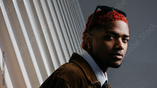 Portrait of black man with red dyed hair looking at camera with serious expression