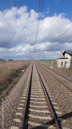 Point of view of a fast moving train traveling along straight railway tracks on a sunny day