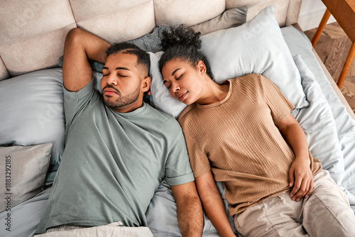 A couple in pajamas sleeping peacefully in a cozy bed, enjoying a healthy and restful morning.