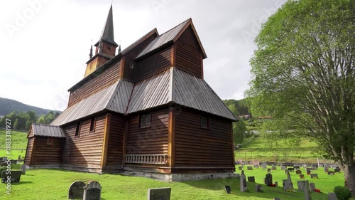 Cinematic view of Kaupanger Stave Church in Norway, with ancient tombstones in the foreground with no one. A peaceful, historic Viking landscape with no people