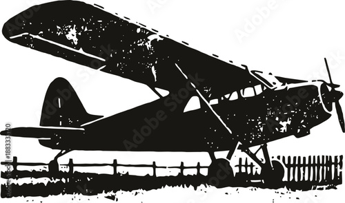 Vintage small airplane silhouette flying over wooden fence outdoors