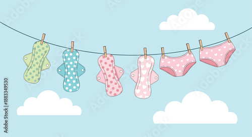 Reusable fabric sanitary pads and pink underwear hanging from a clothesline against a blue sky for sustainable period care.