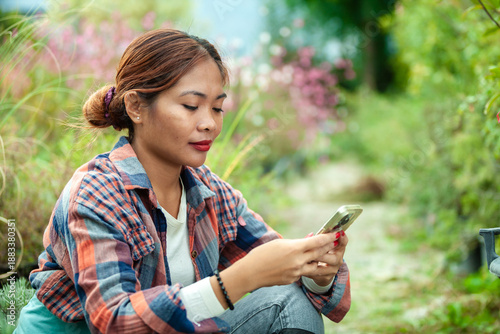 Woman using smart phone in a garden