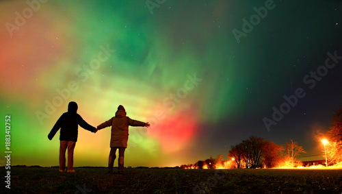 Two people looking at Northern lights aurora borealis Lund Sweden 19.01.2026
