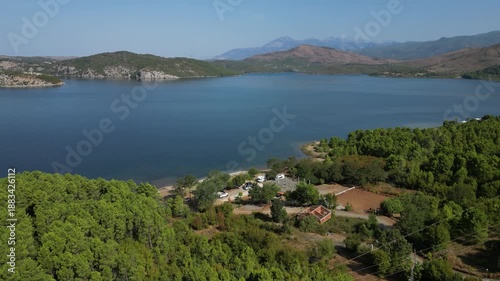 Wallpaper Mural Aerial drone view of a small campsite and RV parking area on the forested shores of Lake Komani, Albania, featuring turquoise water and rugged mountain peaks in the Balkan wilderness. Torontodigital.ca