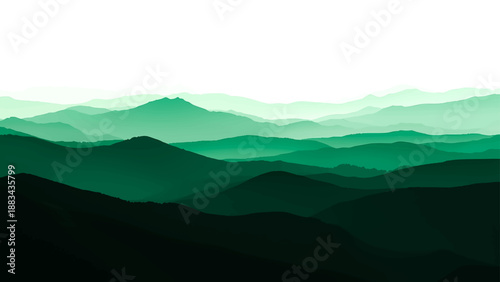 Misty mountain landscape featuring a sunset view over blue hills and a silhouetted forest range partially hidden by soft clouds and fog at dawn