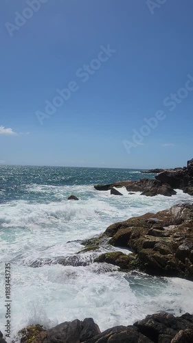 Turquoise Waves and White Sea Foam Crashing on Coastal Rocks
