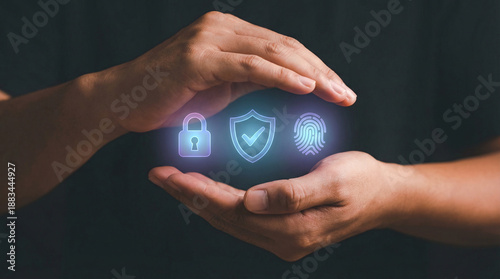 Photos Hands holding glowing cybersecurity hologram featuring lock shield and fingerpri
