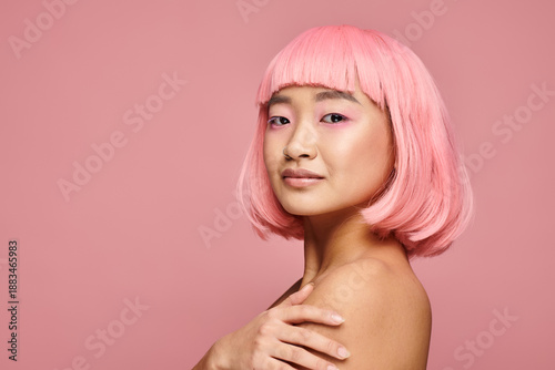 Obraz na plátne Young woman with vibrant pink hair showcases beauty against soft pink backdrop