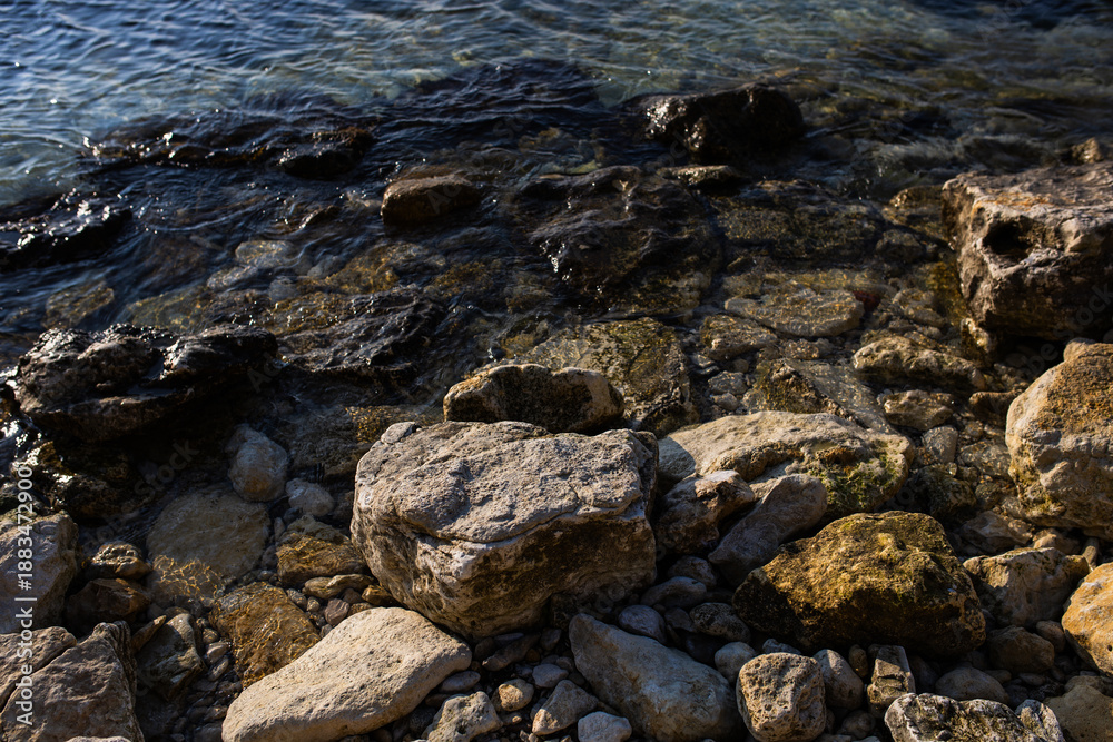 Obraz premium large stones near the seashore in the winter season. a stone beach in an environmentally friendly resort town. concept: tourism and beach recreation 