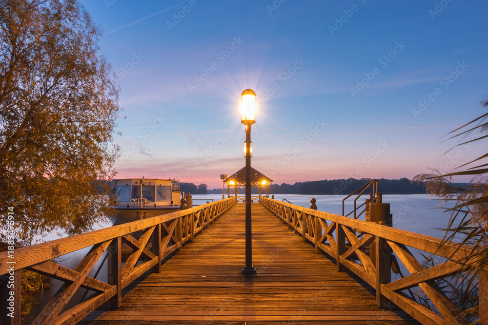Obraz premium Steg am See in Neuruppin mit Aussichtsplattform am Ende bei Sonnenaufgang im Herbst