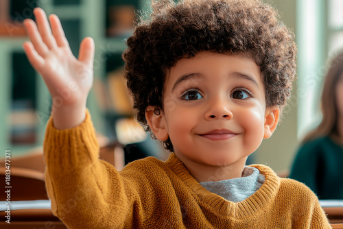 Child waves hand in classroom setting during learning activity