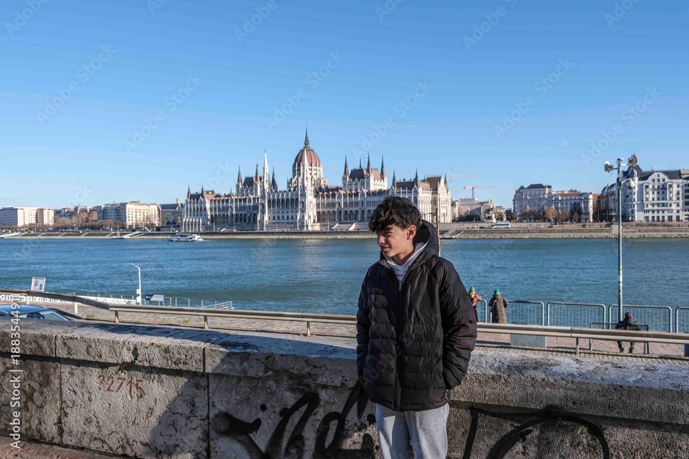Fototapeta premium Young man enjoying budapest danube river cityscape and parliament building