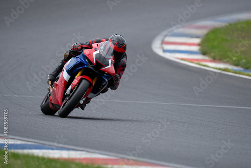 фотографія High angle view of a professional rider on a red sport motorcycle leaning into a