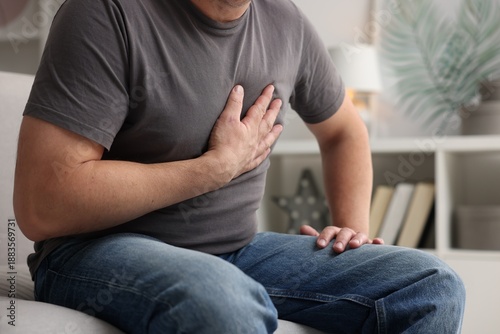 Photos Heart attack. Man suffering from pain in chest indoors, closeup