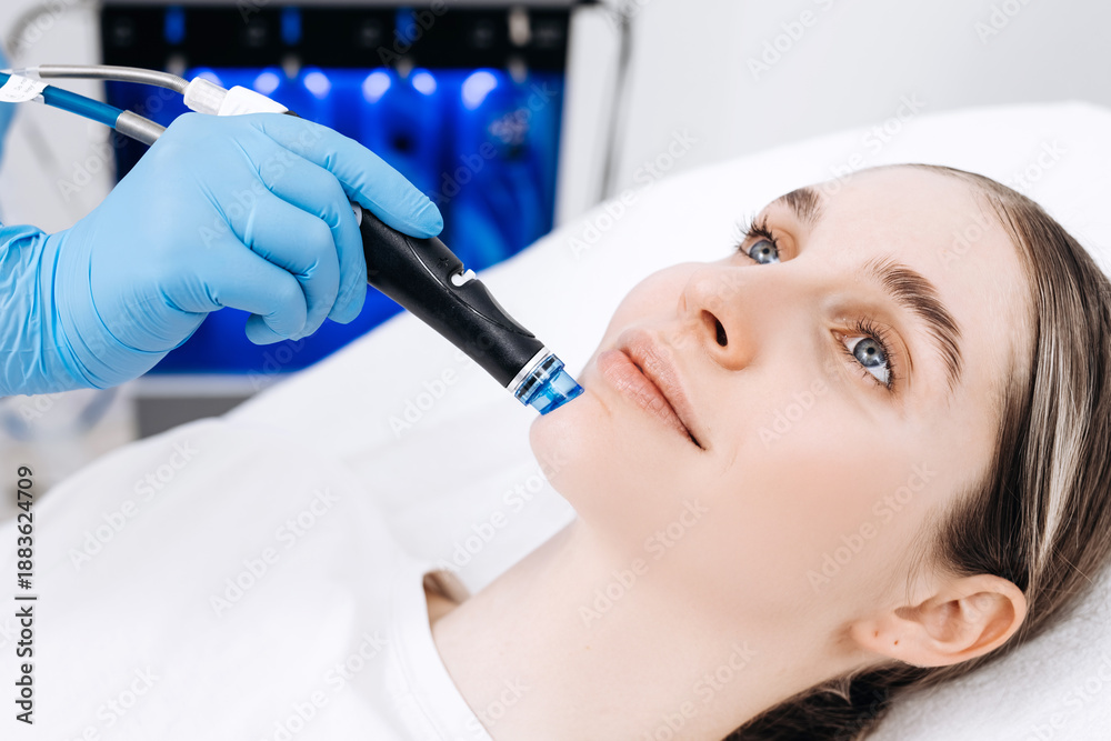 Naklejka premium Cosmetologist performs a hydrafacial treatment on a client in a skincare clinic. Concept skincare, facial treatment, beauty care