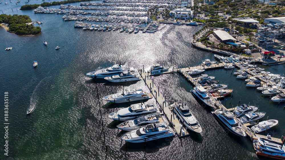 Naklejka premium Luxury yachts in marina with sun reflecting on the water 