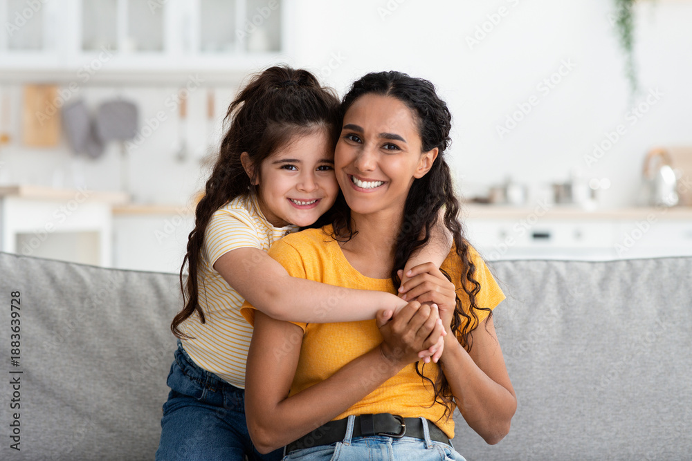 © Prostock-studio - Mother's Day Concept. Portrait Of Happy Young Arab Woman And Her Cute Little Daughter Embracing At Home And Smiling At Camera, Middle Eastern Mom And Female Child Enjoying Time Together, Copy Space © Prostock-studio - Mother's Day Concept. Portrait Of Happy Young Arab Woman And Her Cute Little Daughter Embracing At Home And Smiling At Camera, Middle Eastern Mom And Female Child Enjoying Time Together, Copy Space