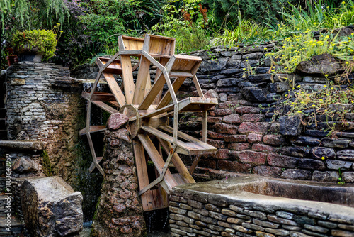 Photos The photograph shows an old wooden mill that pumps water for watering the garden and vegetable garden