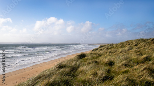 Vászonkép Waves crashing along the grassy shore and sandy beach of Laggan Bay on the Isle of Islay in Scotland
