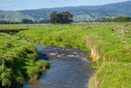 the small Mangaone Stream drains farmland in the Te Horo region of the Kapiti Coast in the North Island of New Zealadn. In the background the Tararua Ranges