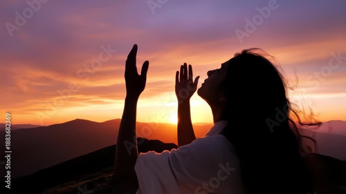 Woman praying looking up with hands open to sky silhouette beautiful sunset