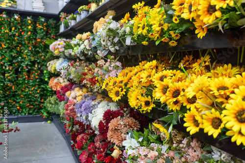 Schilderij op canvas Colorful display of a wide variety of artificial floral arrangements on the shelves
