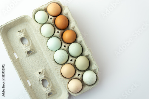 Half dozen colorful fresh eggs in cardboard carton