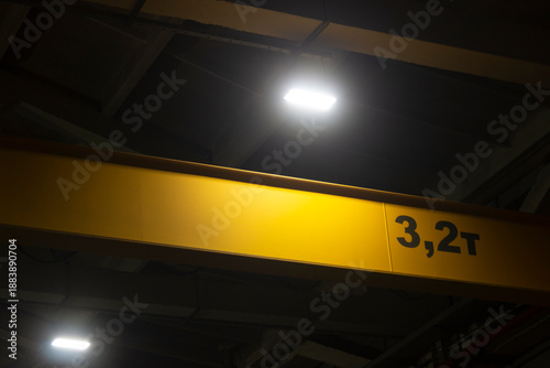 LED lighting projector in a dark production workshop, ventilation devices, windows and concrete structures