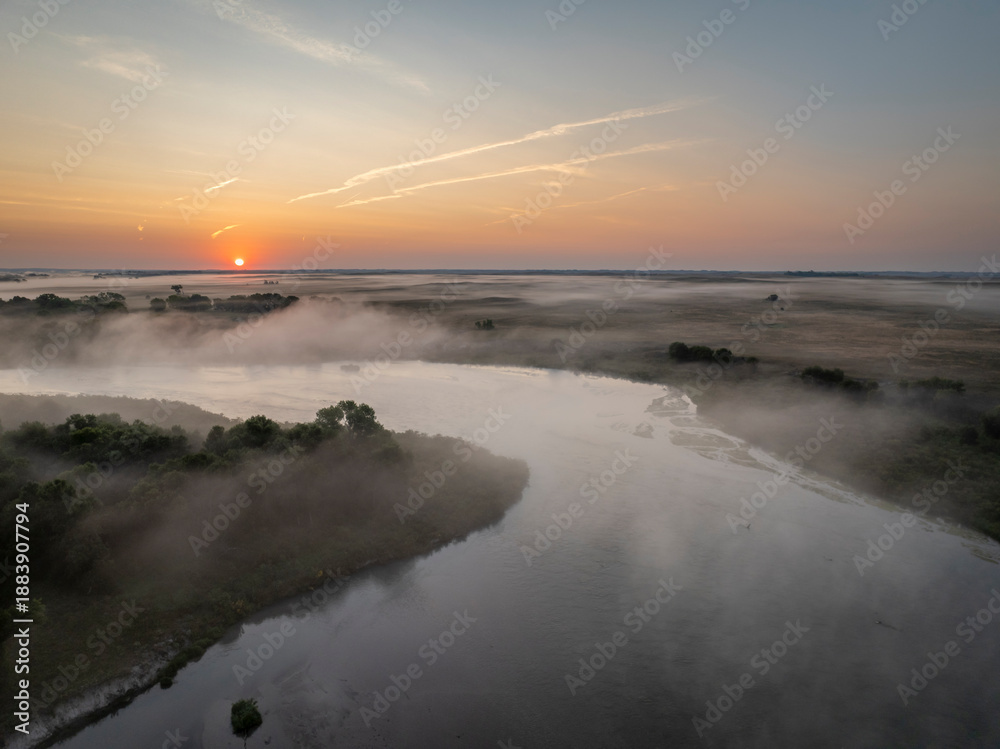 Obraz premium foggy sunrise over the Dismal River in Nebraska Sandhills at Nebraska National Forest, late summer morning scenery