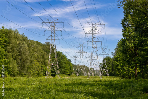 High-voltage power line in a forest clearing. Power transmission towers in the forest